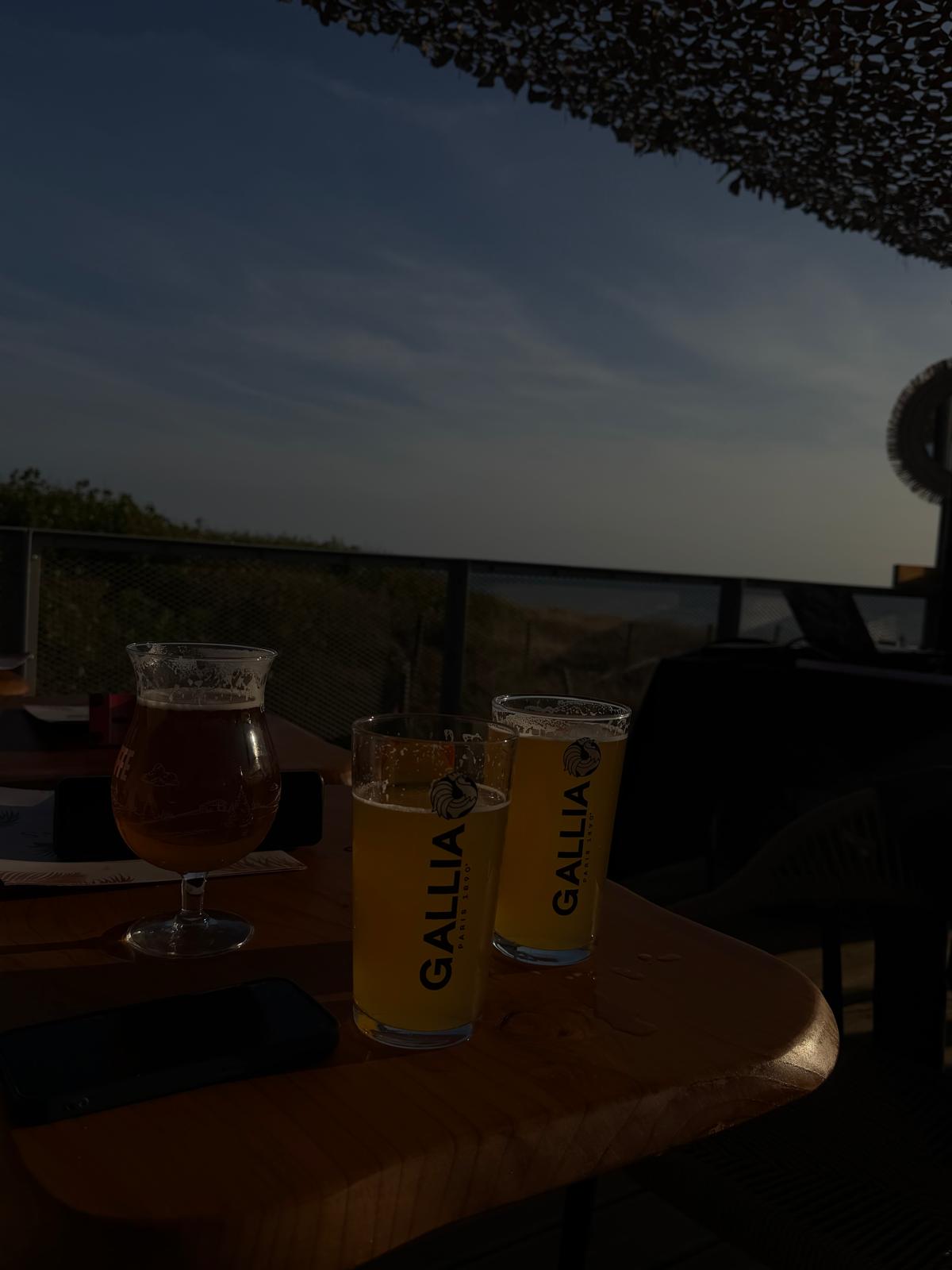 Bières Gallia et verre tulipe face à l'océan à l'heure bleue depuis la terrasse